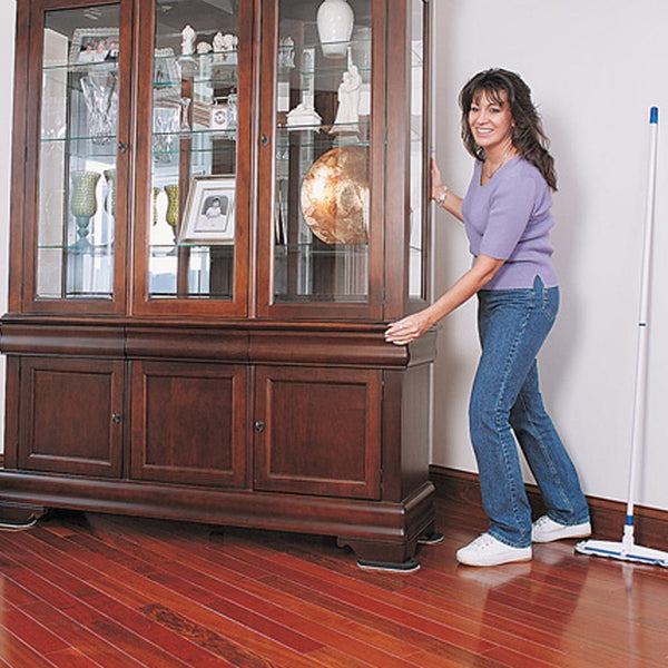 Woman with sweeper moving china cabinet across red hardwood floor with Professional Furniture Slides for Hardwood and Tile (Set of 4)