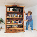 Woman moving bookcase with EZ Moves II Furniture Slides for Carpet (Set of 4)