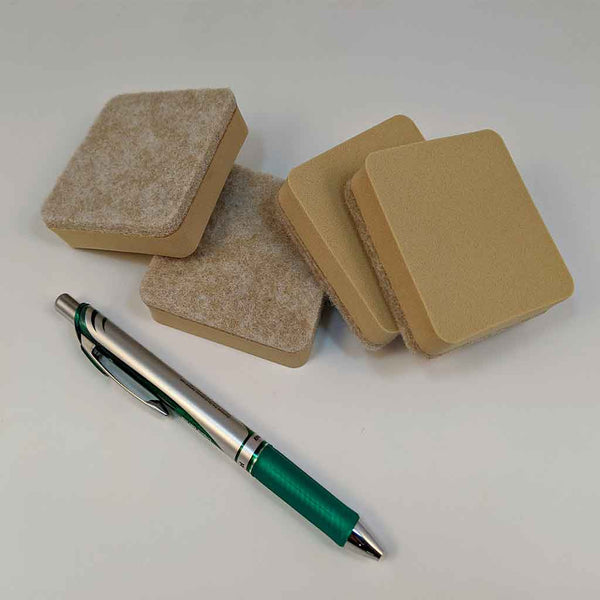 Unpackaged set of beige Permanent Furniture Slides for Hard Surfaces, Square (Set of 4) next to an ink pen.